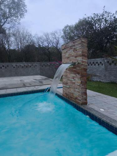 a water fountain in a swimming pool at Chácara Fim de Tarde in Barra do Garças