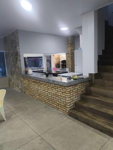 a kitchen with a brick counter and stairs in a room at Chácara Fim de Tarde in Barra do Garças