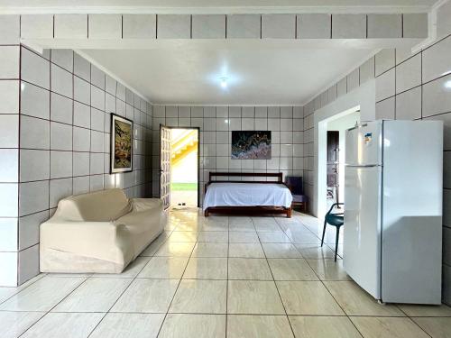 a bedroom with a bed and a refrigerator at Nossa pousada in Imbituba