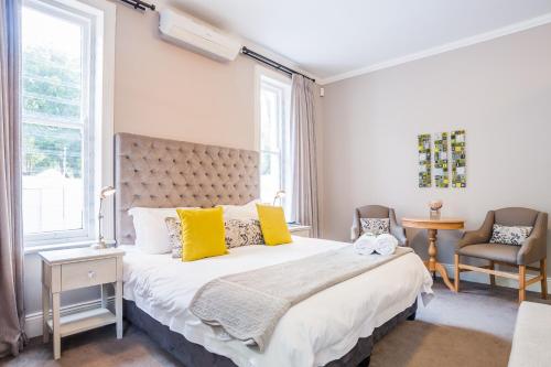 a bedroom with a large bed with yellow pillows at Bonne Esperance Boutique Guest House in Stellenbosch