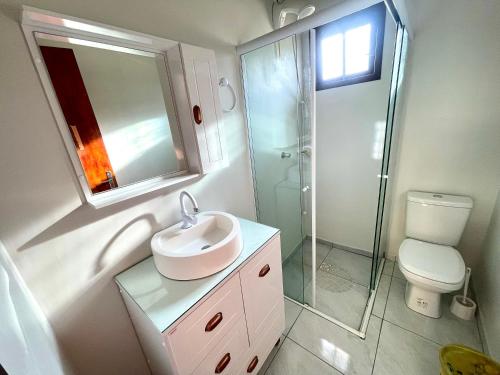 a bathroom with a sink and a shower and a toilet at Nossa pousada in Imbituba