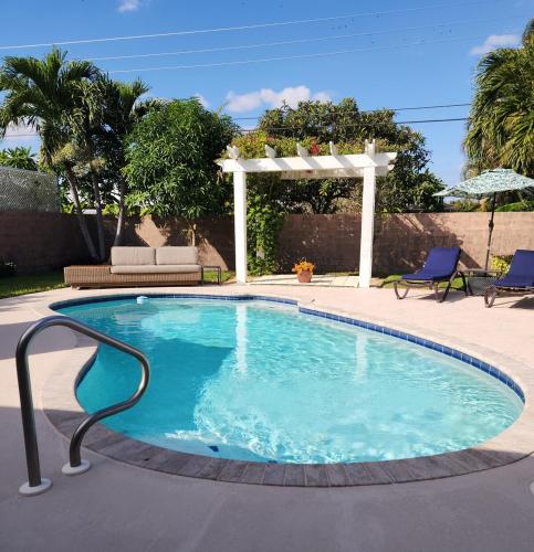 a large swimming pool with a pergola and a swimming poolvisor at Private Oasis!Bike to beach, heated pool in Naples
