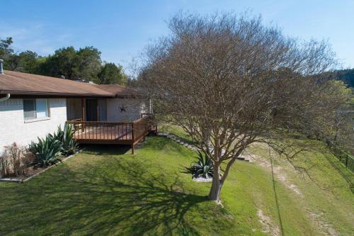 a tree in a yard next to a house at Lazy Southern Getaway in Canyon Lake