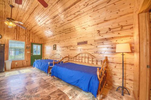 two beds in a room with wooden walls at RR 9122SF Sunflower Cabin in Canyon Lake