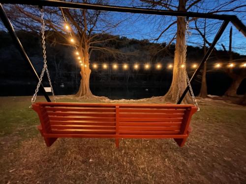 a swing hanging from a tree at night at RR 7134 River Repose in Canyon Lake