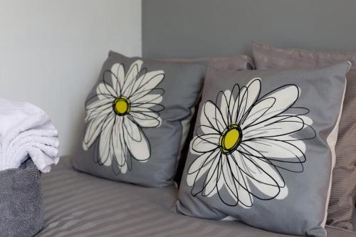 two pillows with daisies on them sitting on a couch at Beautiful 5Bedroom House - Contractors and Family near the Molineux stadium in Wolverhampton