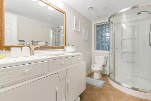 a white bathroom with a shower and a toilet at Modern Spacious Ocean-view Suite with Private Ent in West Vancouver