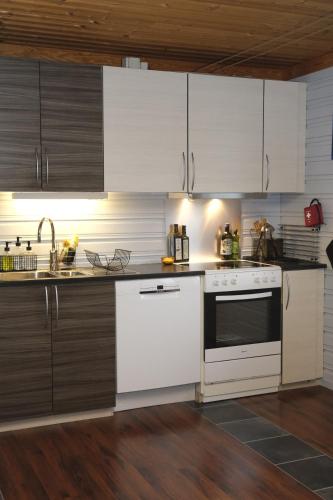 a kitchen with white appliances and wooden cabinets at 3ART recreation in Tromsø