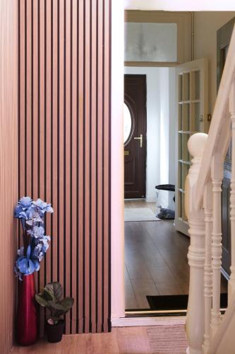 a hallway with a vase with blue flowers in it at Beautiful 5Bedroom House - Contractors and Family near the Molineux stadium in Wolverhampton