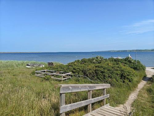 a wooden bench on the side of a beach at 5 star holiday home in Lemvig-By Traum in Lemvig
