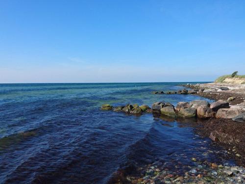 a group of rocks on the shore of the ocean at 6 person holiday home in Karrebæksminde-By Traum in Karrebæksminde