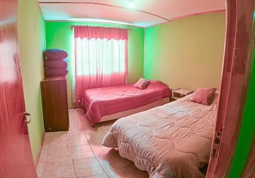 a room with two beds in a room with green at Cabaña familiar cerca del mar en Caleta Olivia in Caleta Olivia