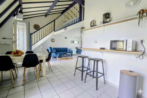 a kitchen and living room with a table and chairs at COEUR de Sainte Anne-Appartement à 50 m de la PLAGE-vue MER-Clim in Sainte-Anne