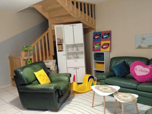 a living room with two green couches and a staircase at Maison familiale EXCELLENCE,3 chambres jardin avec jeux, proche gare Bourg en Bresse in Saint-Denis-lès-Bourg