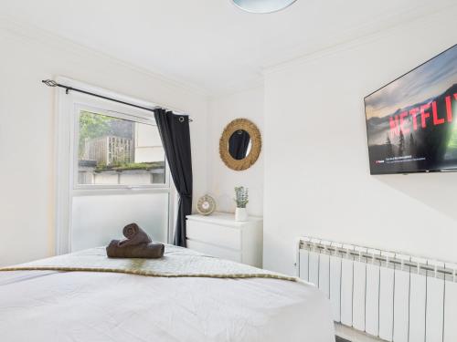 a white bedroom with a teddy bear sitting on a bed at Stylish Maisonette with Hot Tub in Brighton & Hove
