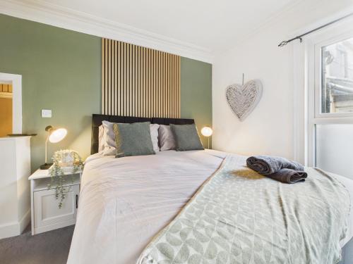 a bedroom with a large bed with a heart on the wall at Stylish Maisonette with Hot Tub in Brighton & Hove