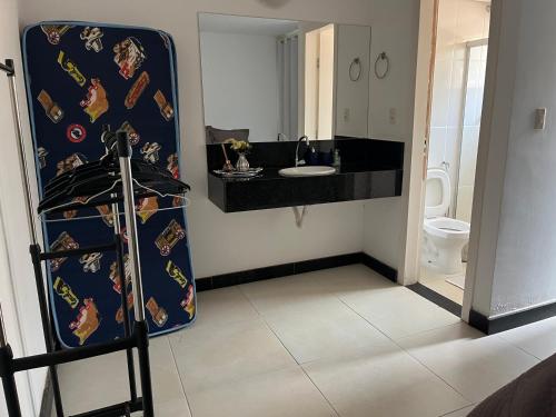 a bathroom with a sink and a toilet at Apartamento Mirante de Escarpas 1703 in Capitólio