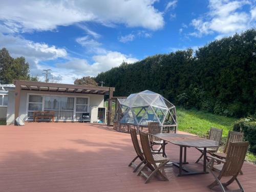 a table and chairs with a tent on a patio at Sea & Mountain Views Retreat on Rosemary Farm in Waihi