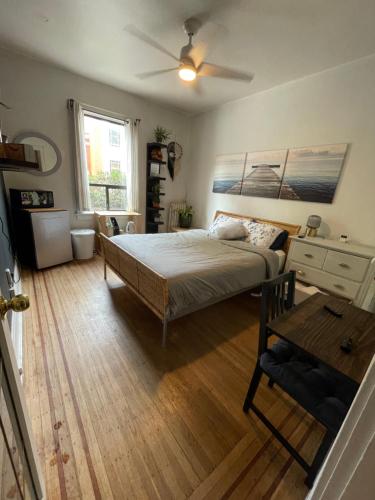 a bedroom with a bed and a table and a window at Ophelias Casa in Vancouver