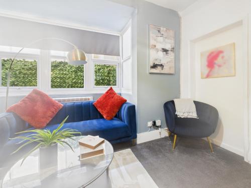 a living room with a blue couch and a glass table at Stylish Maisonette with Hot Tub in Brighton & Hove