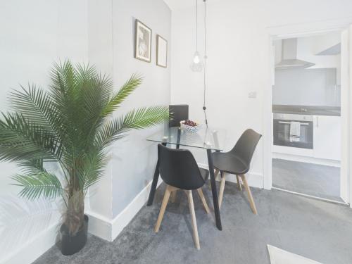 a dining room with a table and two chairs and a palm tree at Stylish Maisonette with Hot Tub in Brighton & Hove