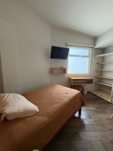 a bedroom with a bed and a desk and a window at Privada 400 in Pachuca de Soto