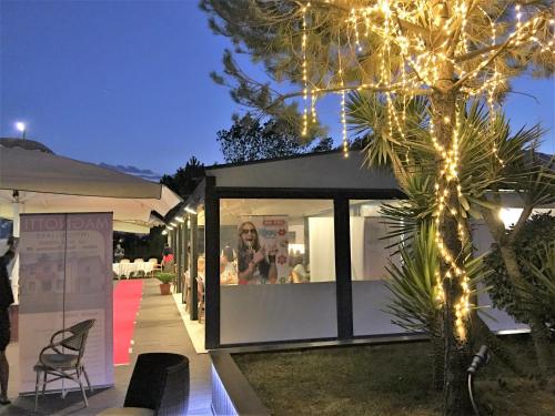 a house with christmas lights on the side of it at Dune Prestige & Chalets in Bibione