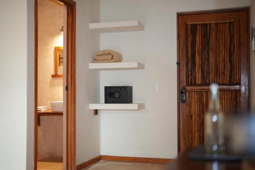 a room with a door and a clock on the wall at Hotel Boutique La Puerta Azul Beachfront - Adults Only in Holbox Island