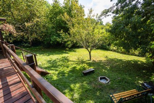 a yard with a bench and a tree at Tiny-House in Paradise - Maringotka v Raji in Turnov