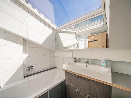 a bathroom with a sink and a tub and a window at Chalet Kirchberg L in Kirchberg in Tirol