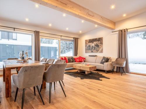 a living room with a table and chairs and a couch at Chalet Hornblick in Fieberbrunn