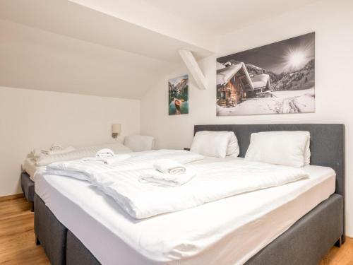 two beds in a room with white sheets at Chalet Hornblick in Fieberbrunn