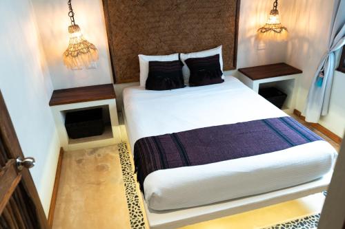 a bedroom with a bed and two night stands at Hotel Boutique La Puerta Azul Beachfront - Adults Only in Holbox Island
