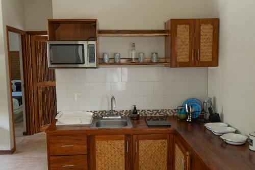 a kitchen with a sink and a microwave at Hotel Boutique La Puerta Azul Beachfront - Adults Only in Holbox Island