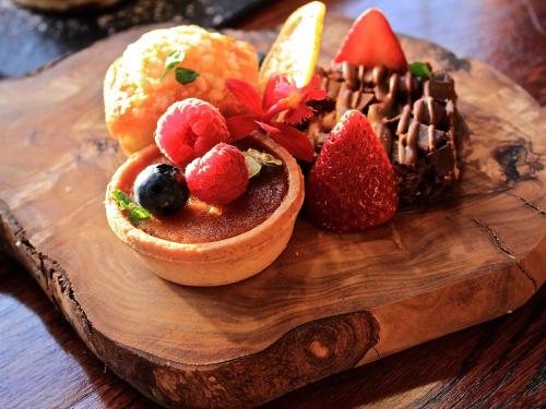 a wooden plate with a dessert with fruit on it at Bedford Lodge Hotel & Spa in Newmarket