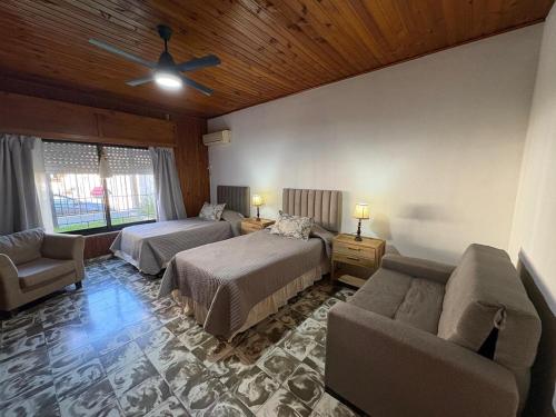 a bedroom with two beds and a couch at Casa Rita in Gualeguaychú