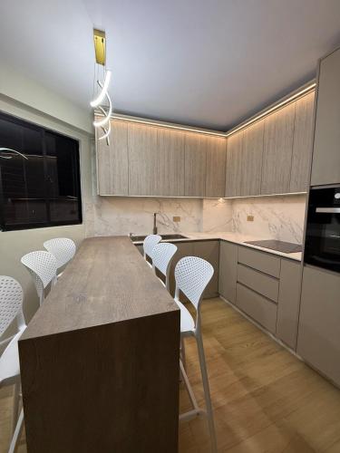 a kitchen with a large wooden table and white chairs at Moderno apartamento 1 minuto de la playa in Chichiriviche