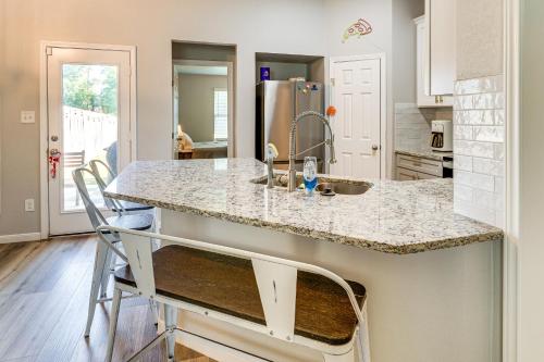 a kitchen with a counter with two chairs at a island at 9 Mi to College Station Dog-Friendly Home with Yard in Bryan