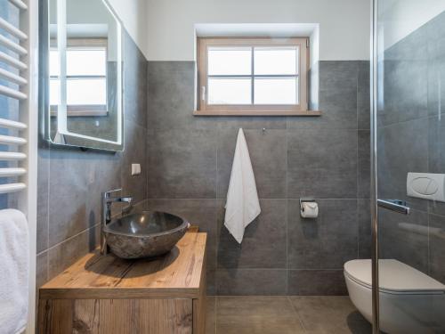 a bathroom with a stone sink and a toilet at Donnersbach Lodge in Donnersbachwald