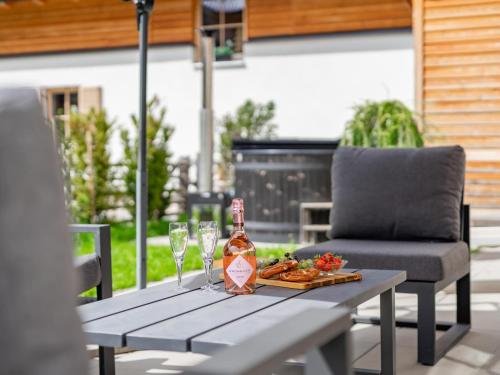 a picnic table with a bottle of wine and glasses at Donnersbach Lodge in Donnersbachwald