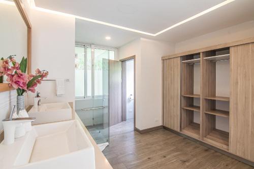 a bathroom with a white sink and a mirror at Luxury Villa Los Pajaros Private Pool & Oceanview in Playa Hermosa