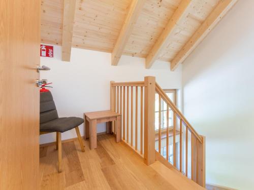 a room with a chair and a wooden staircase at Apart Heidi in Donnersbachwald