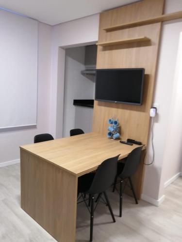 una sala conferenze con tavolo e sedie in legno di Lindo Apartamento no Centro de Rio Grande a Rio Grande