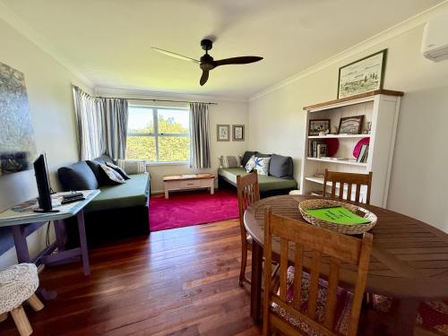 a living room with a table and a couch at 'Noni's House' Coastal Opononi Hokianga in Opononi