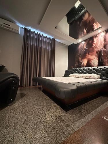 um quarto com uma cama com uma fotografia na parede em Motel Vitoria Reggia em São Vicente