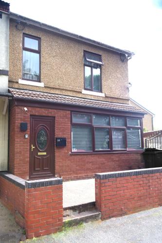 a brick house with a brown door and windows at Beautiful 5Bedroom House - Contractors and Family near the Molineux stadium in Wolverhampton