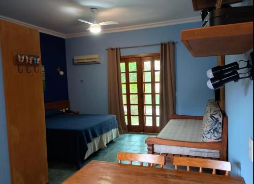 a bedroom with a bed and a window and a table at Flat 4-109 in Ilhabela