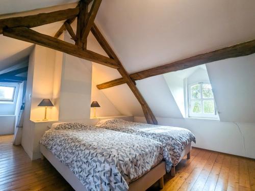 a bedroom with a bed in an attic at Maison de vacances en Brenne avec piscine partagée, grand jardin et tout confort inclus - FR-1-591-329 in Bélâbre