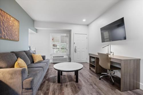 a living room with a couch and a desk at University Park Inn & Suites, an Ascend Collection Hotel in Davis