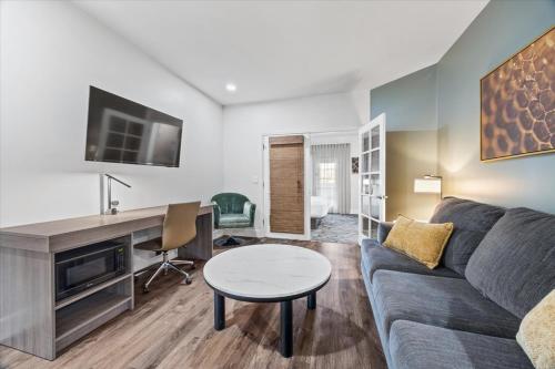 a living room with a couch and a desk at University Park Inn & Suites, an Ascend Collection Hotel in Davis